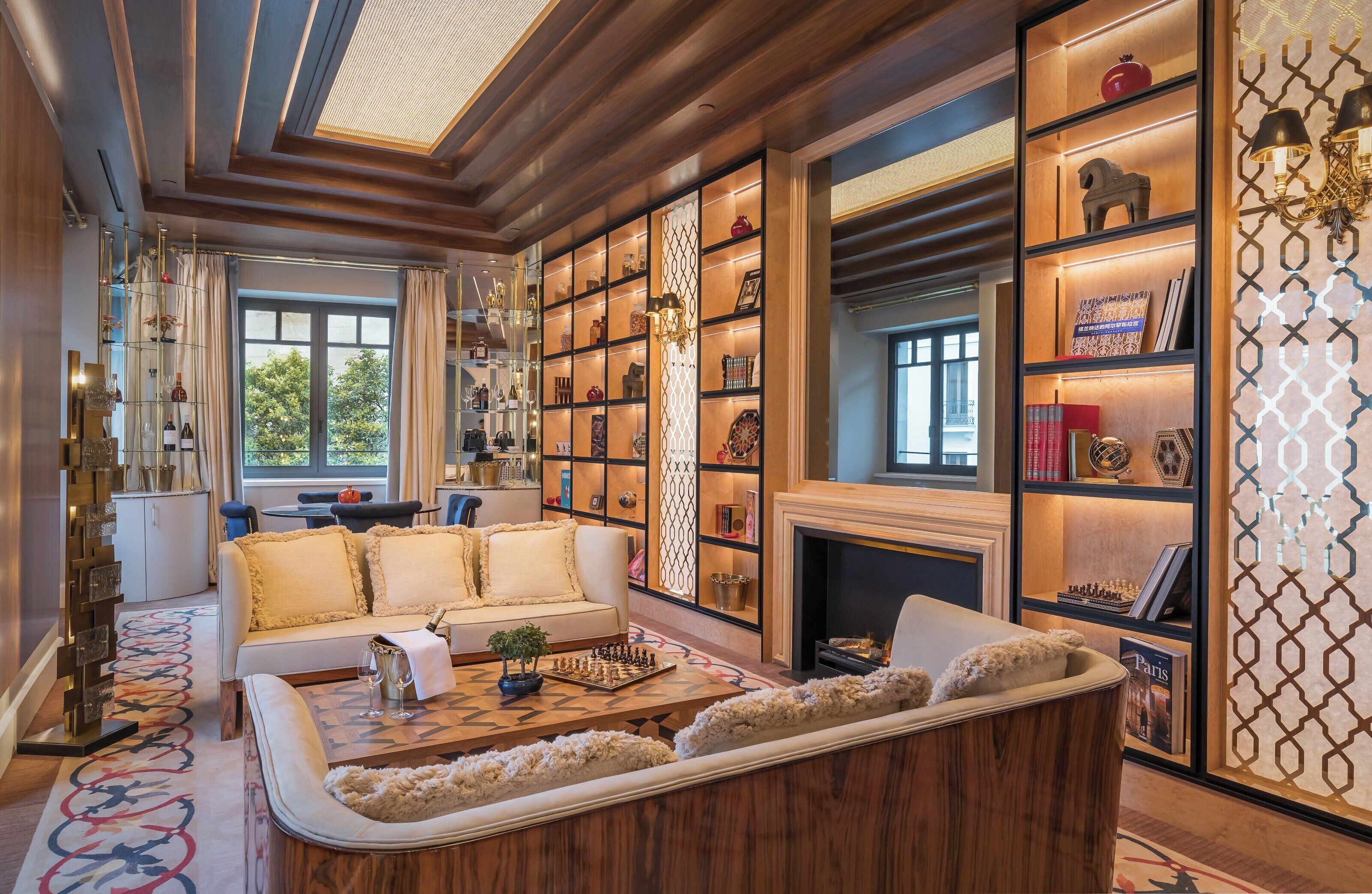 A spacious living room with a fireplace, a large bookshelf, and a comfortable seating area.