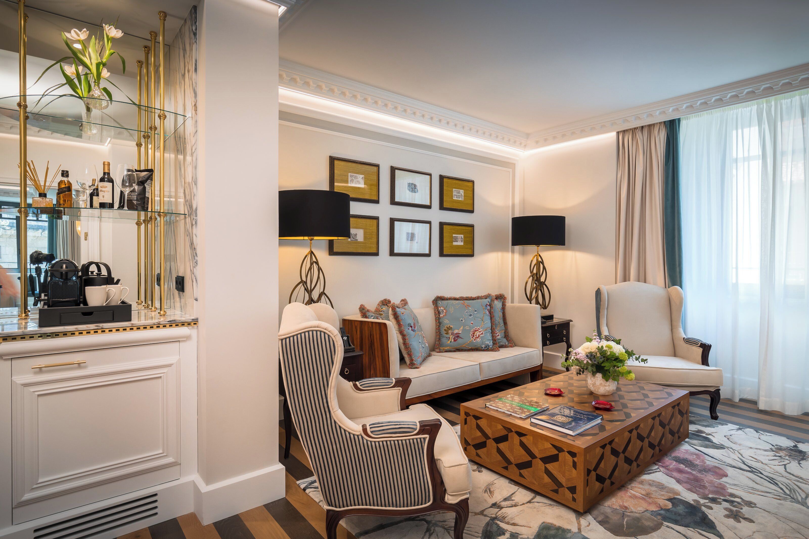 Un salon moderne comprenant un canapé, des fauteuils, une table basse, une cheminée et des œuvres d’art encadrées accrochées au mur.