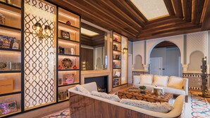 A modern living room with a fireplace, a wooden coffee table, and a bookshelf with decorative items.