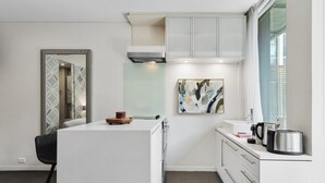 Une cuisine moderne avec des meubles blancs, un grand îlot central et une fenêtre offrant une belle vue.
