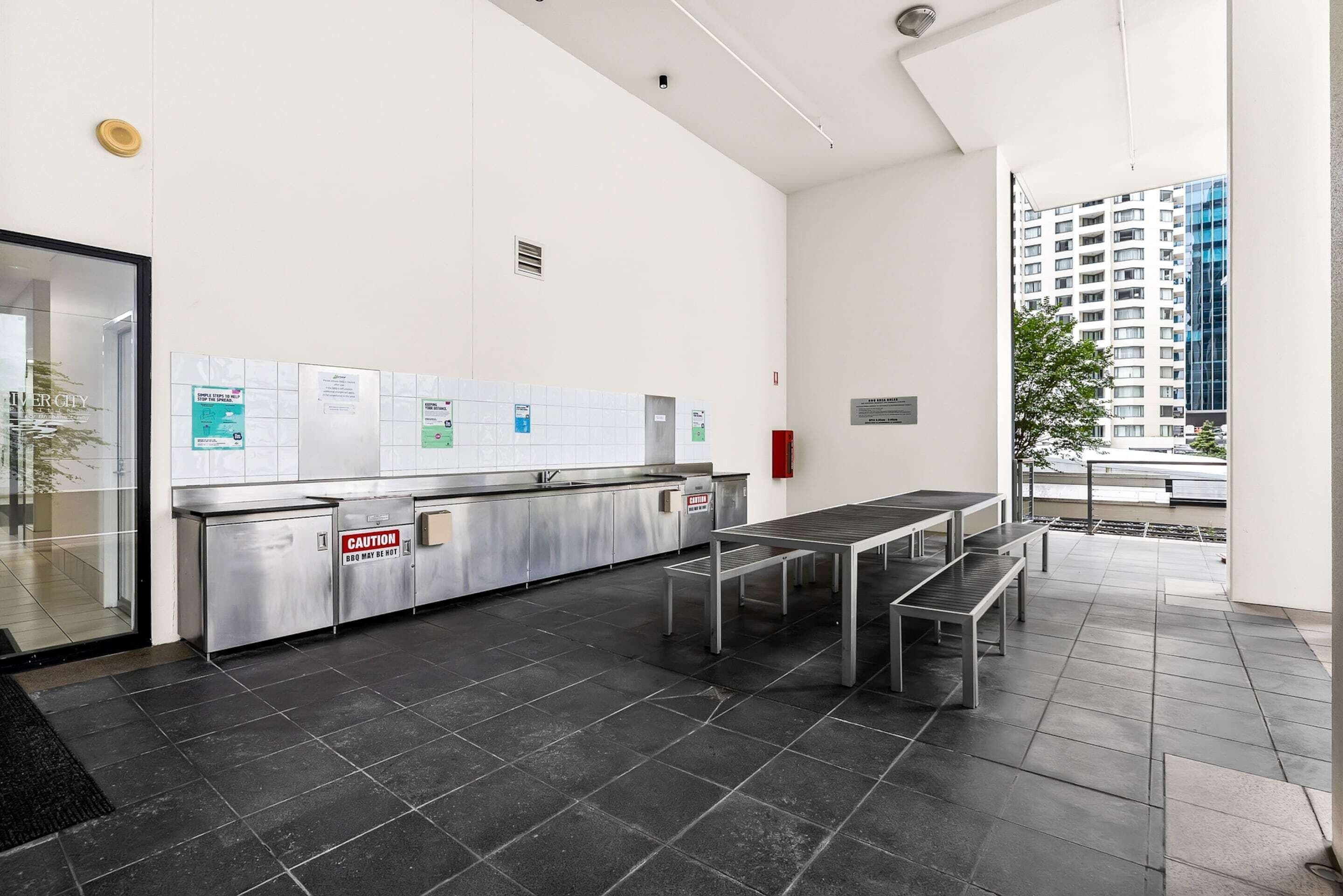 A modern indoor area with a long counter, a bench, and a view of a building through a window.