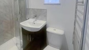 A modern bathroom with a glass shower enclosure, a sink, and a toilet. - Britannia Road. (Great Yarmouth)