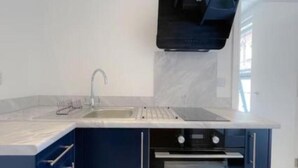 A modern kitchen with a built-in oven and a stainless steel sink. - Britannia Road. (Great Yarmouth)