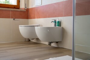 Kylpyhuoneessa on kaksi wc:tä, pesuallas ja ikkuna pesualtaan yläpuolella.