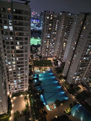 Un immeuble résidentiel de grande hauteur doté de nombreux balcons, d’une piscine sur le toit et d’une cour bien éclairée.