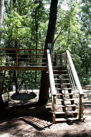 A wooden staircase leading up to a platform in a forested area.