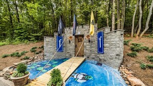 A stone building with a wooden deck and a swimming pool with a mural.