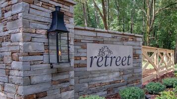 A stone wall with a 'retreat' sign and a lantern.