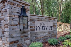 A stone wall with a 'retreat' sign and a lantern.