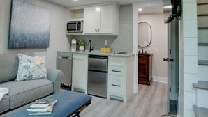 A modern apartment with a loft-style living area, a kitchenette, and a dining area.
