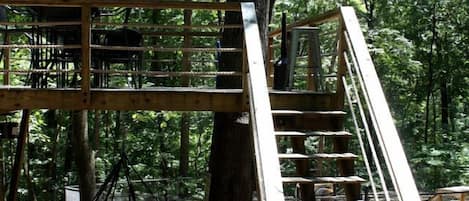 A wooden staircase leading up to a platform in a forested area.