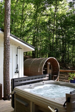 Ein Whirlpool mit Holzbottich-Konstruktion in bewaldeter Landschaft.