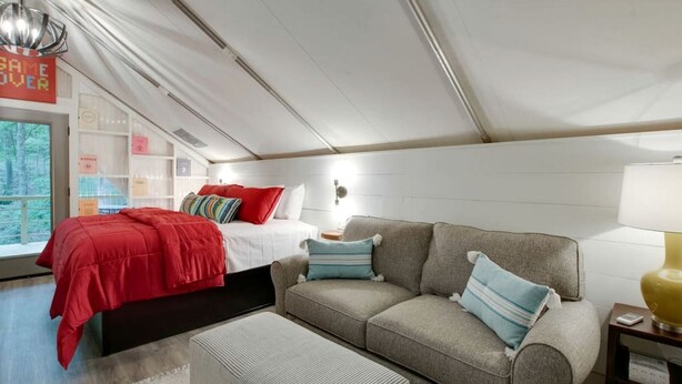 Ein modernes Interieur mit Bett, Sofa und Leseplatz.