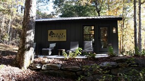 A small building with a sign reading 'Leaf & Stone Spa' and two wicker chairs outside.
