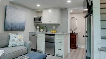 A modern apartment with a loft-style living area, a kitchenette, and a dining area.