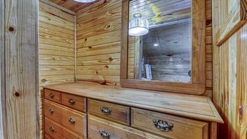 A wooden interior with a dresser, drawers, and a mirror.