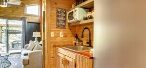Una cocina acogedora con armarios de madera, un microondas de estilo vintage y un fregadero.