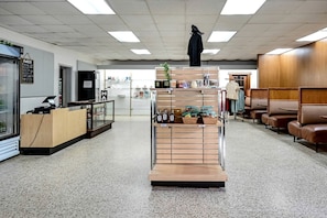 Un'area receptione con un banco, una rastrelliera espositiva e posti a sedere.
