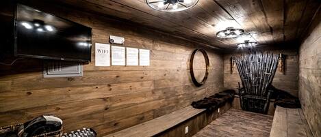 Un interior de madera con un televisor, un cartel que indica la disponibilidad de WiFi y un espejo montado en la pared.