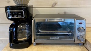 Une machine à café et un grille-pain sur une surface en bois.