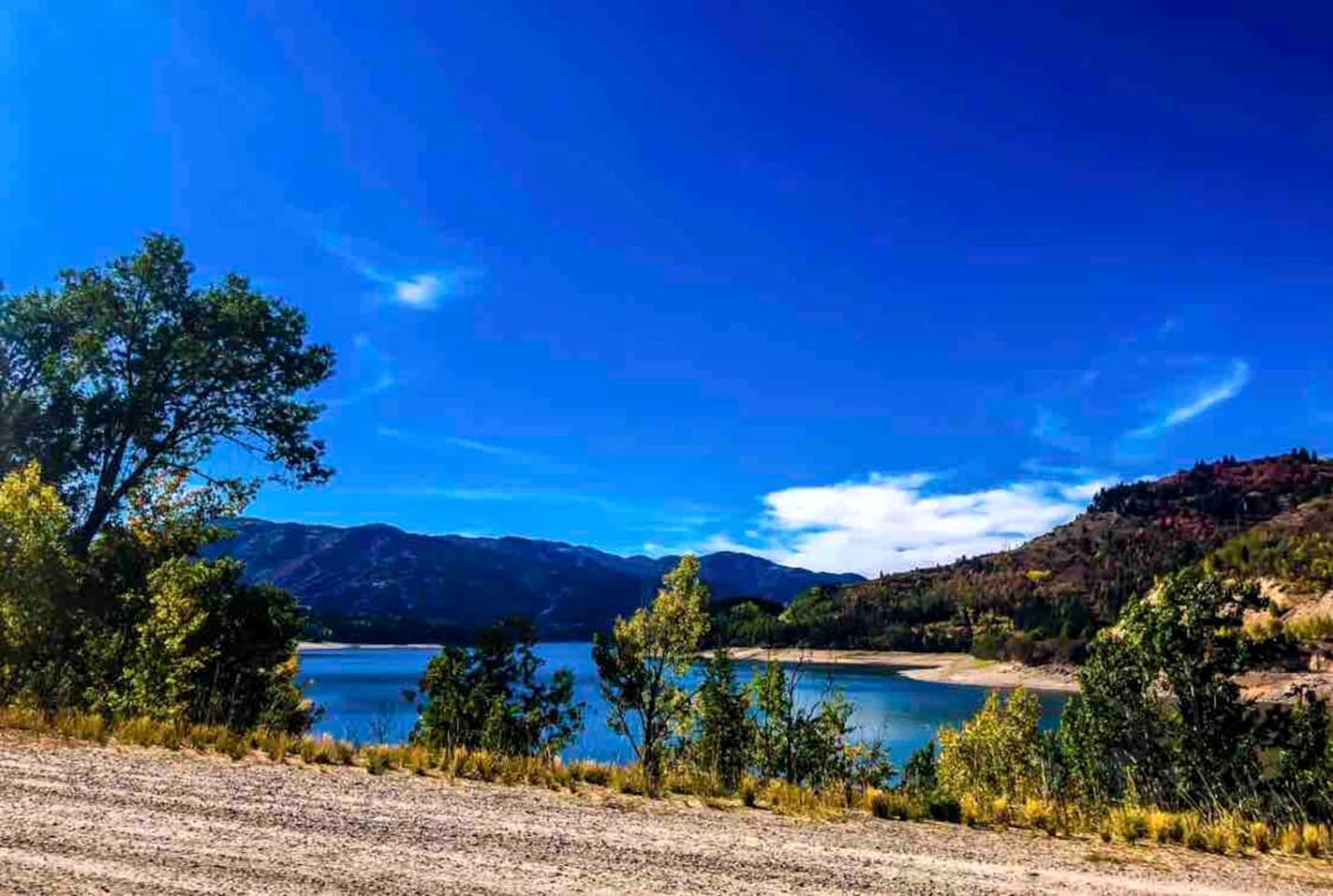 A natural landscape with a lake, mountains, and trees.