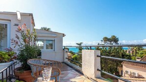 A balcony with a table, chairs, and potted plants. - Villa 50 meters from the sea sea view in the heart of the village of st Aygulf (Fréjus)