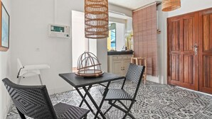 A dining area with a table and chairs, a hanging light fixture, and a patterned floor. - Villa 50 meters from the sea sea view in the heart of the village of st Aygulf (Fréjus)