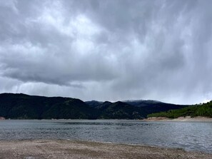 A lake with a forested mountain backdrop.