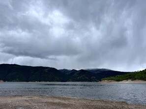 A lake with a forested mountain backdrop.