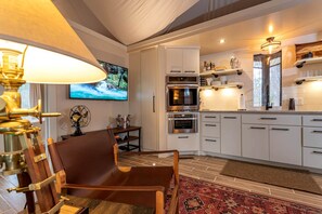 A modern kitchen with white cabinets, stainless steel appliances, and a red patterned rug.