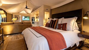 Une chambre d’hôtel moderne équipée d’un grand lit, d’un canapé, d’une télévision et d’une kitchenette.