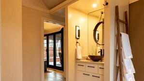 Une salle de bain moderne avec un grand miroir, une baignoire blanche et une cabine de douche en verre.
