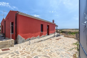 Ein rotes Gebäude mit einem pflasterbelagten Eingang und blauem Himmel.