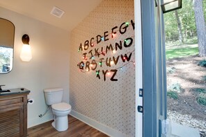 Une salle de bain avec des toilettes, un lavabo et un miroir.