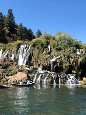 Una cascada amb una barca al primer pla.
