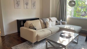 A modern living room with a sofa, a coffee table, and artwork on the wall.