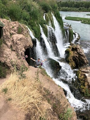 A waterfall with a person standing on a rock formation. - Charming Swan Valley Cottage with Clubhouse Access Near Palisades Lake, Idaho (Irwin)