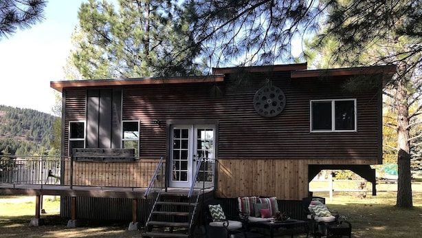 A cabin with a deck, a staircase, and outdoor seating. - Beautiful Tiny House with Wrap-Around Deck and Skylight for a Romantic Escape in Irwin, Idaho (Irwin)