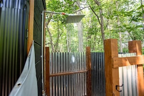 A metal gate with a wooden post, a metal structure with a horizontal beam, and a metal fence.