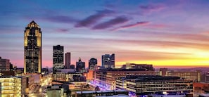 Une vue panoramique d’une ville avec de nombreux immeubles de grande hauteur, un bâtiment particulièrement imposant avec un sommet pointu, et un mélange d’architecture moderne et plus ancienne.