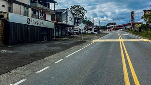 A street with a hotel named ENSUENO on the left, a gas station in the distance, and a clear sky. - Hotel Ensueño (Pereira)