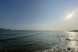 Un mar tranquilo con cielo despejado y tierra a lo lejos.