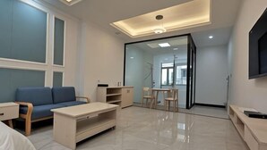 Una sala de estar moderna con sofá, televisor y comedor.