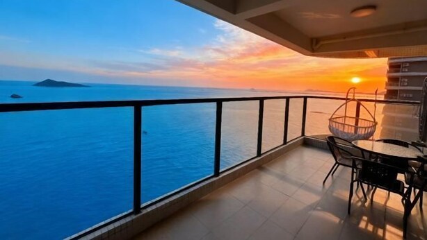 Un balcón con vista al mar y al atardecer.