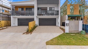 A modern two-story house with a garage, a balcony, and a well-maintained lawn. - Riverside 3-bed Home With Study Nook and BBQ (Murrumba Downs)