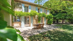 Ein Haus mit Terrasse, Esstisch und Stühlen.