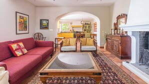 Ein Wohnzimmer mit rotem Sofa, Couchtisch aus Holz und Kamin.
