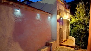 Un petit espace extérieur bien éclairé, avec une seule marche menant à une porte portant l’inscription « 103 ».
