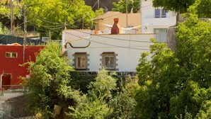 Un immeuble d’habitation avec une porte rouge, une façade blanche et une cheminée.