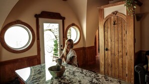 A kitchen with a marble countertop, a wooden door, and a window.